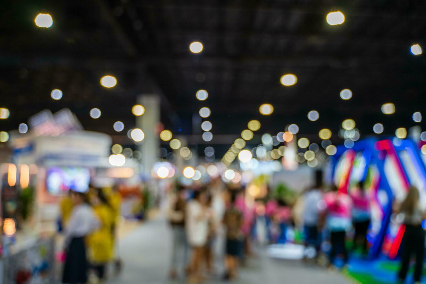 Blurred images of trade fairs in the big hall. image of people walking on a trade fair exhibition or expo where business people show innovation activity and present products in a big hall. photo