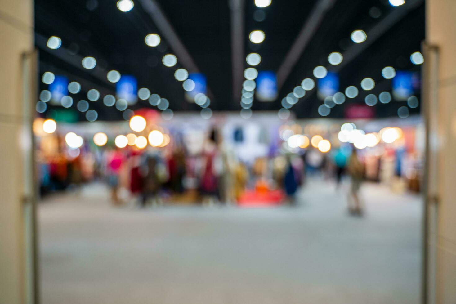 Blurred images of trade fairs in the big hall. image of people walking on a trade fair exhibition or expo where business people show innovation activity and present products in a big hall. photo