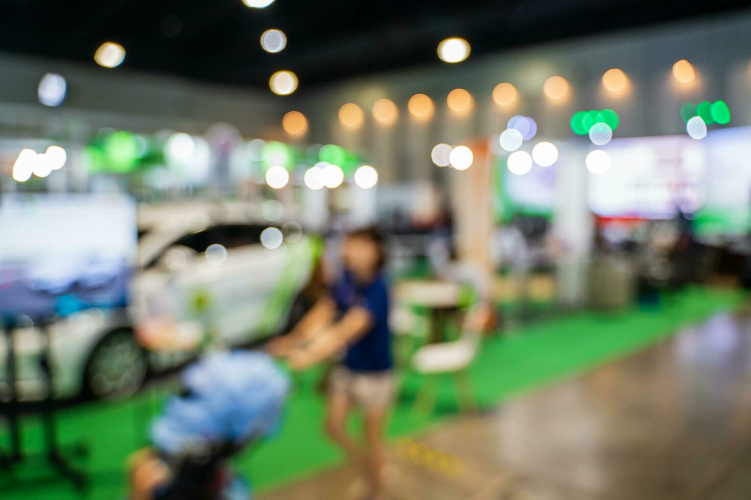 Blurred images of trade fairs in the big hall. image of people walking on a trade fair exhibition or expo where business people show innovation activity and present products in a big hall. photo