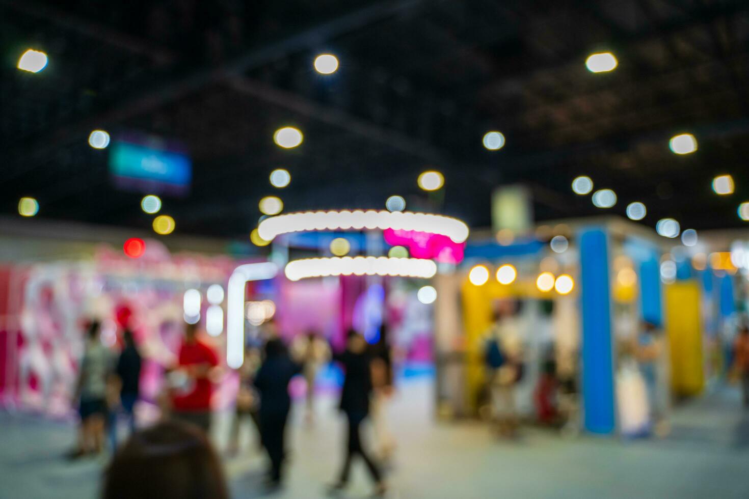 Blurred images of trade fairs in the big hall. image of people walking on a trade fair exhibition or expo where business people show innovation activity and present products in a big hall. photo