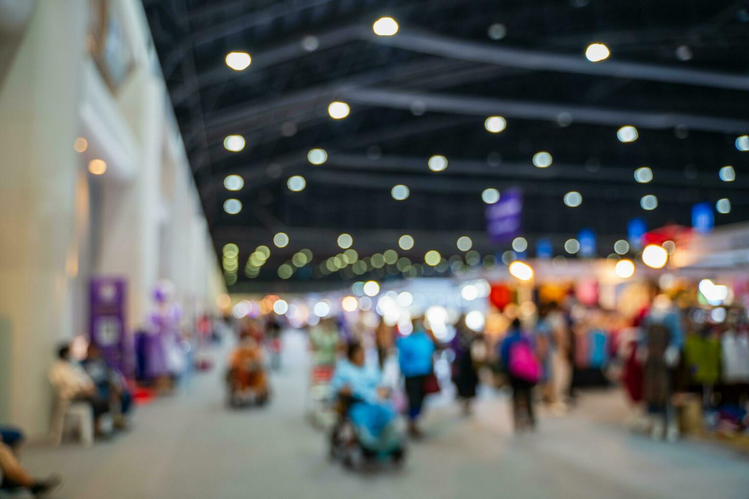 Blurred images of trade fairs in the big hall. image of people walking on a trade fair exhibition or expo where business people show innovation activity and present products in a big hall. photo