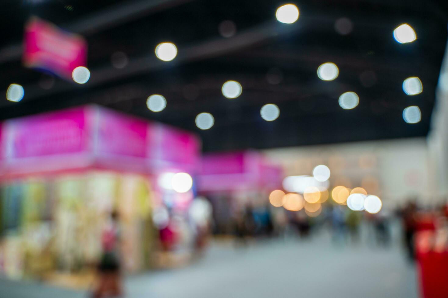 Blurred images of trade fairs in the big hall. image of people walking on a trade fair exhibition or expo where business people show innovation activity and present products in a big hall. photo
