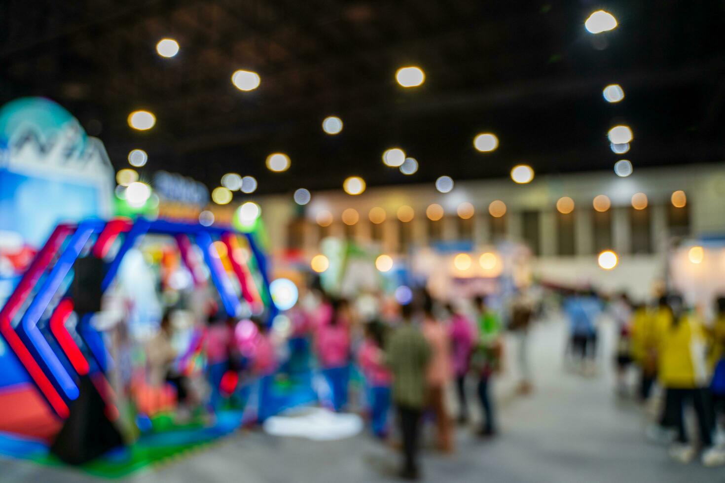 Blurred images of trade fairs in the big hall. image of people walking on a trade fair exhibition or expo where business people show innovation activity and present products in a big hall. photo