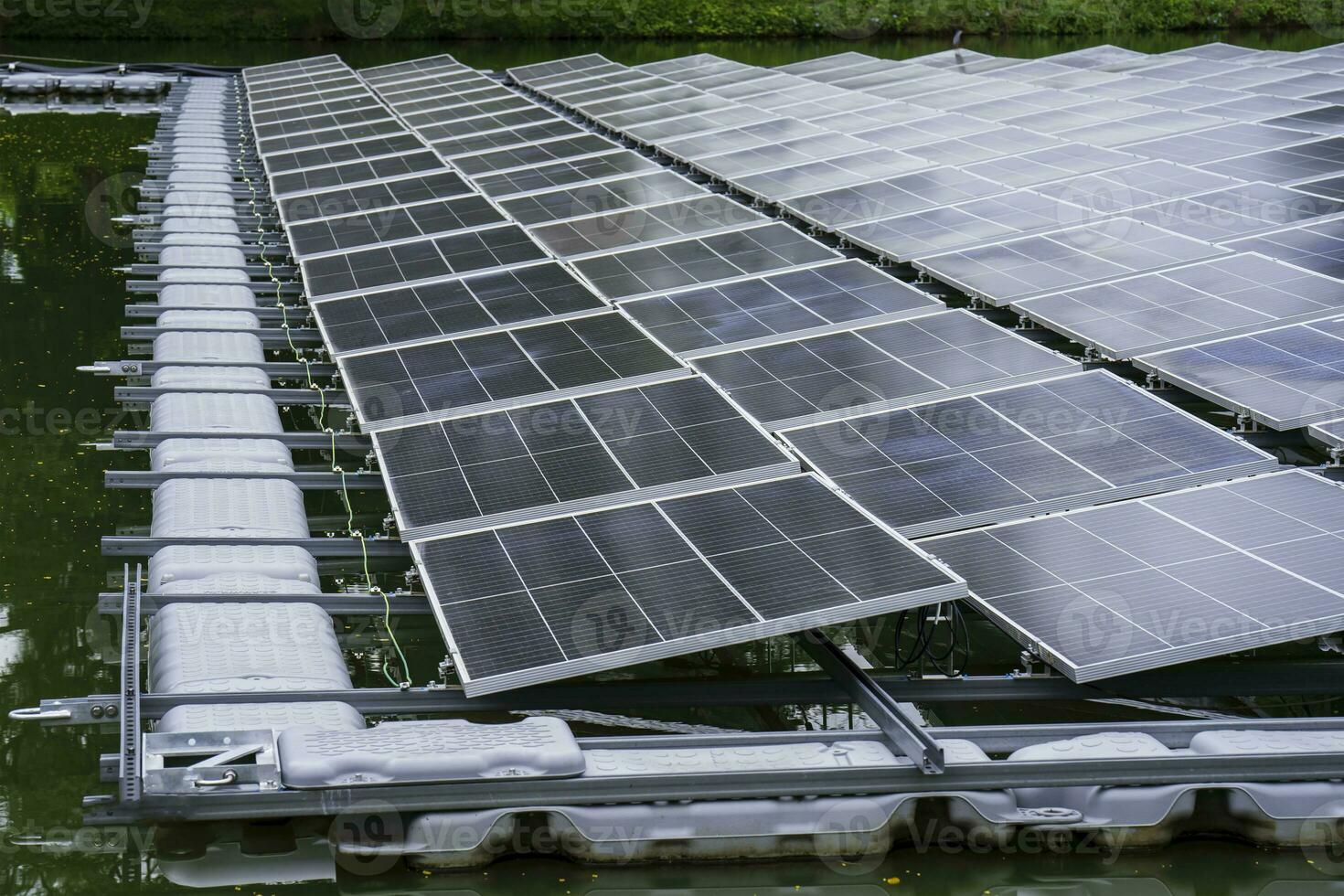 Side view of solar panels floating on water in a lake, for generating electricity from sunlight, selective focus, soft focus. photo