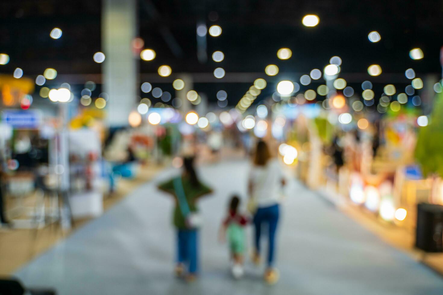 Blurred images of trade fairs in the big hall. image of people walking on a trade fair exhibition or expo where business people show innovation activity and present products in a big hall. photo