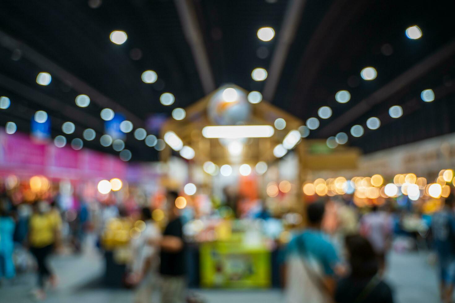 Blurred images of trade fairs in the big hall. image of people walking on a trade fair exhibition or expo where business people show innovation activity and present products in a big hall. photo