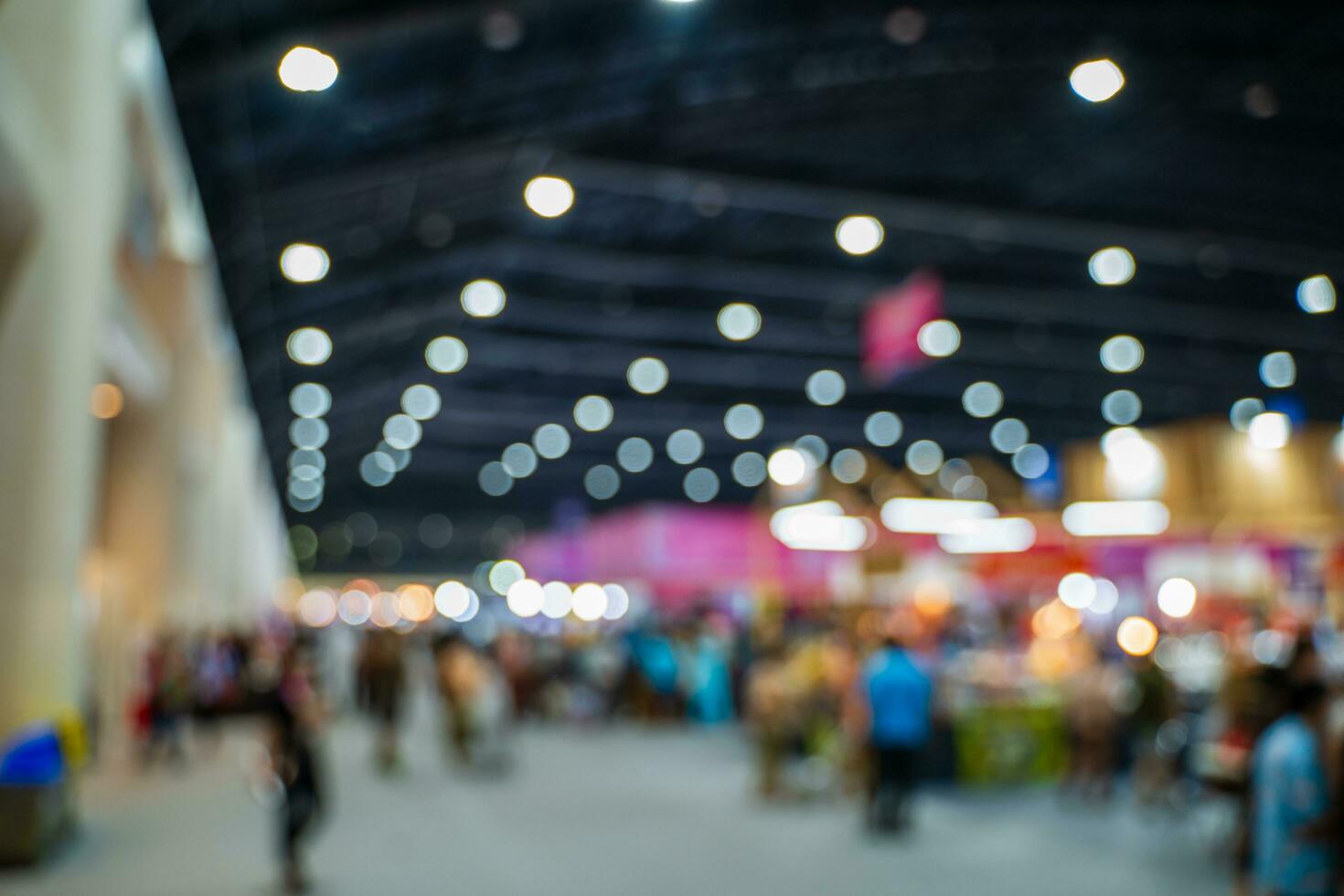 Blurred images of trade fairs in the big hall. image of people walking on a trade fair exhibition or expo where business people show innovation activity and present products in a big hall. photo