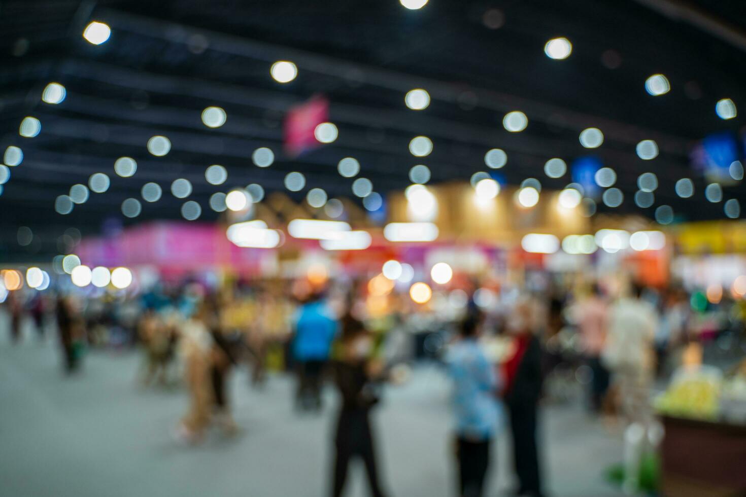 Blurred images of trade fairs in the big hall. image of people walking on a trade fair exhibition or expo where business people show innovation activity and present products in a big hall. photo