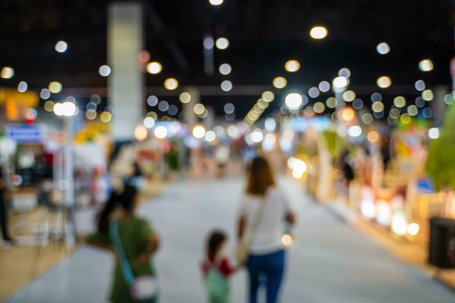 Blurred images of trade fairs in the big hall. image of people walking on a trade fair exhibition or expo where business people show innovation activity and present products in a big hall. photo