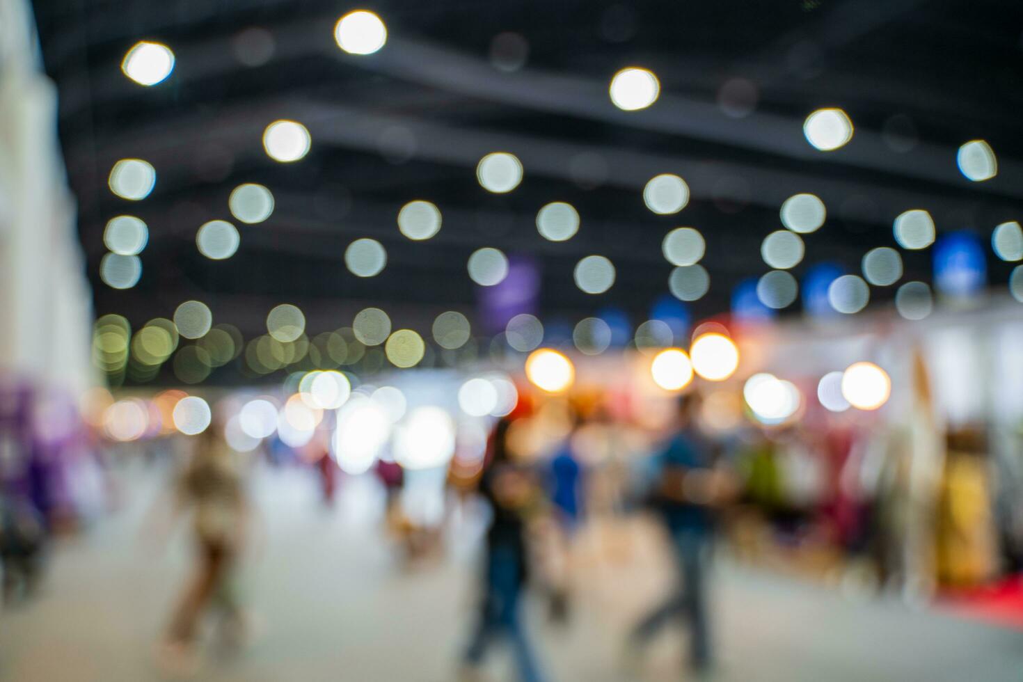 Blurred images of trade fairs in the big hall. image of people walking on a trade fair exhibition or expo where business people show innovation activity and present products in a big hall. photo