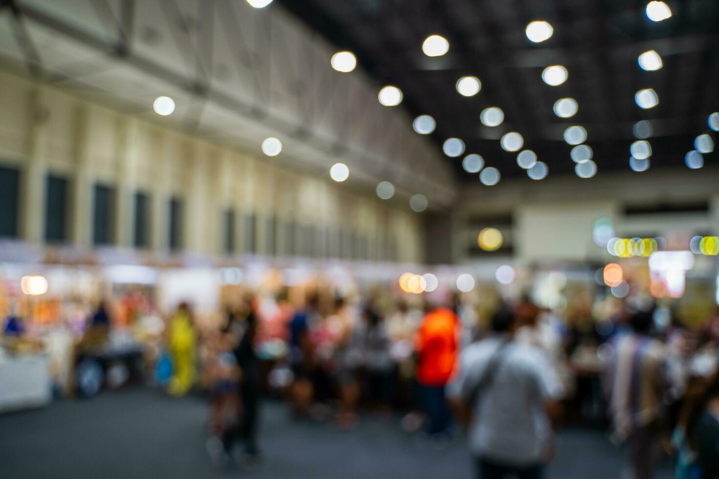 Blurred images of trade fairs in the big hall. image of people walking on a trade fair exhibition or expo where business people show innovation activity and present products in a big hall. photo