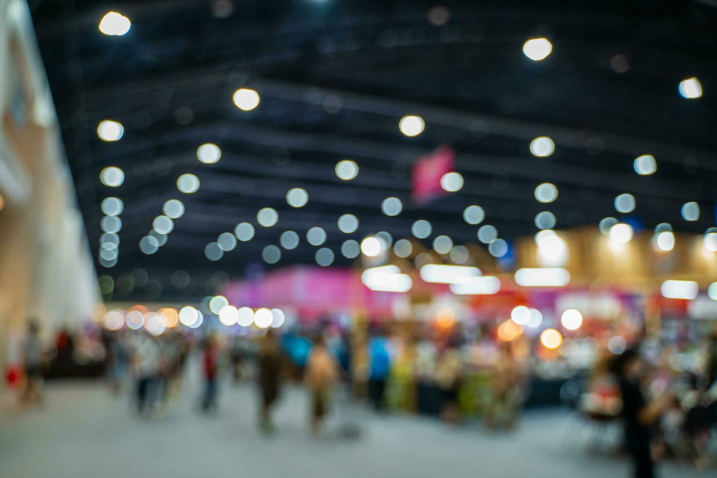 Blurred images of trade fairs in the big hall. image of people walking on a trade fair exhibition or expo where business people show innovation activity and present products in a big hall. photo