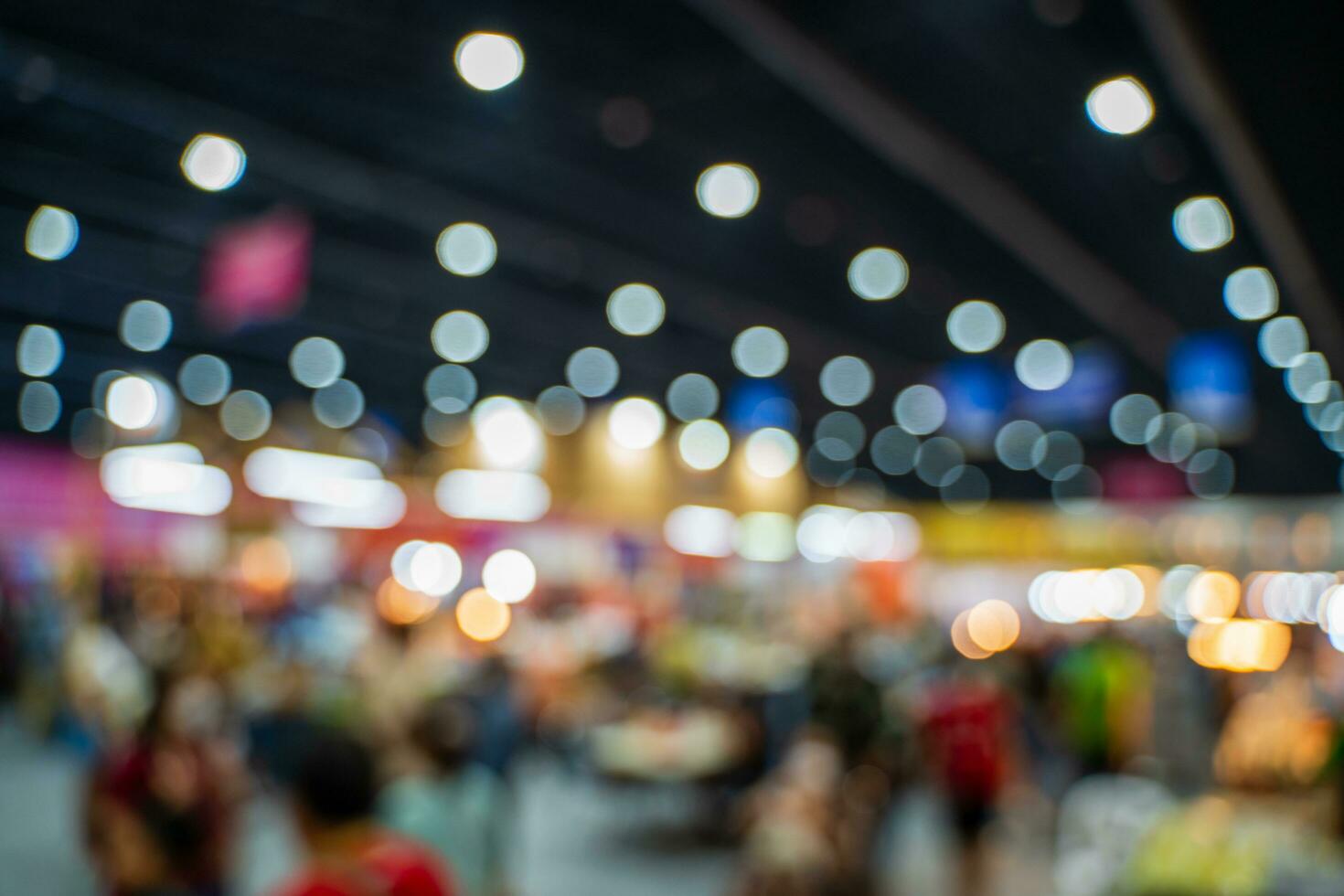 Blurred images of trade fairs in the big hall. image of people walking on a trade fair exhibition or expo where business people show innovation activity and present products in a big hall. photo