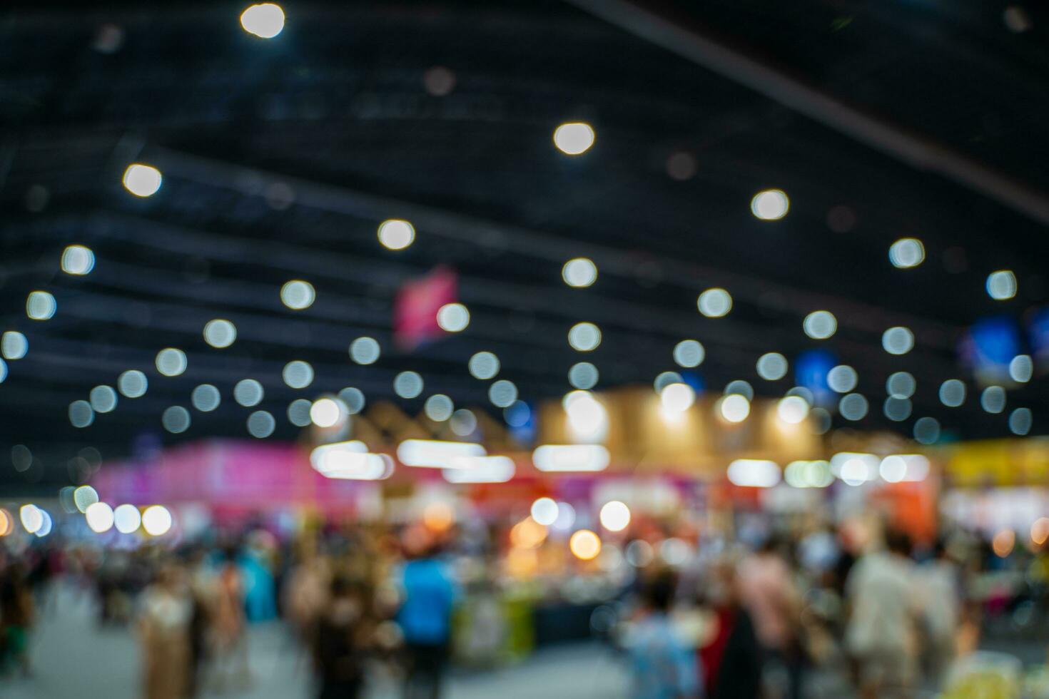 Blurred images of trade fairs in the big hall. image of people walking on a trade fair exhibition or expo where business people show innovation activity and present products in a big hall. photo