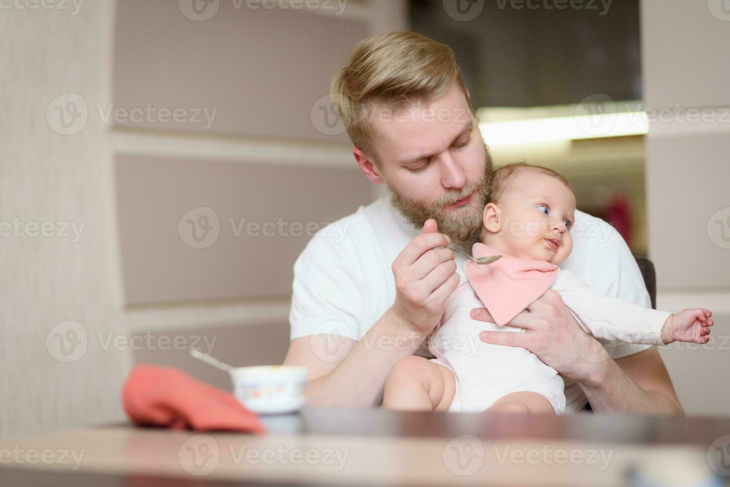 Father feeds his naughty little daughter who refuses to eat complementary foods photo