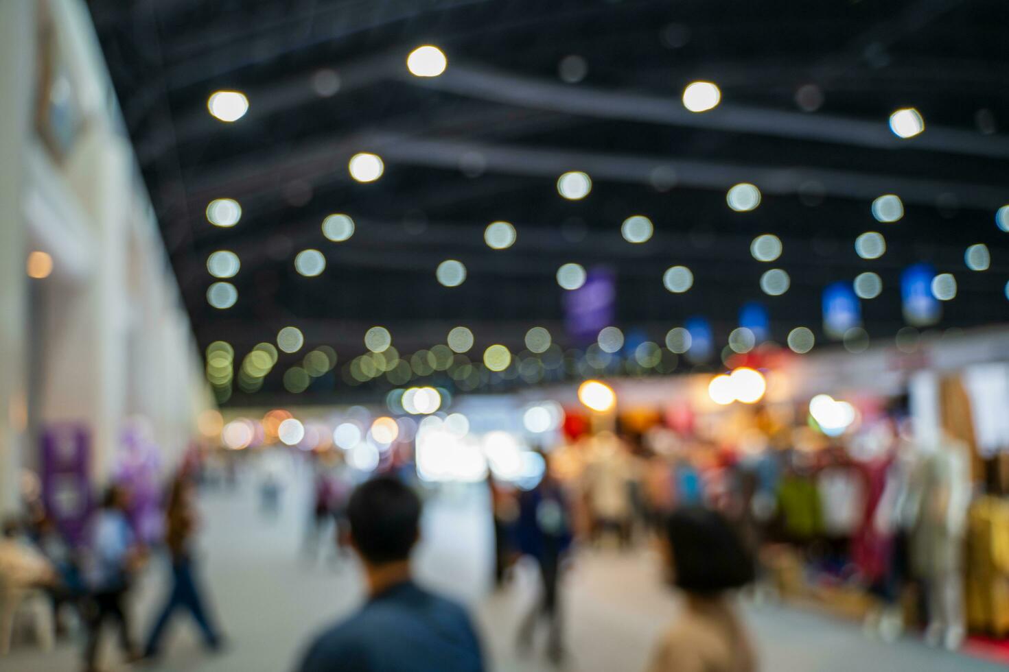 Blurred images of trade fairs in the big hall. image of people walking on a trade fair exhibition or expo where business people show innovation activity and present products in a big hall. photo