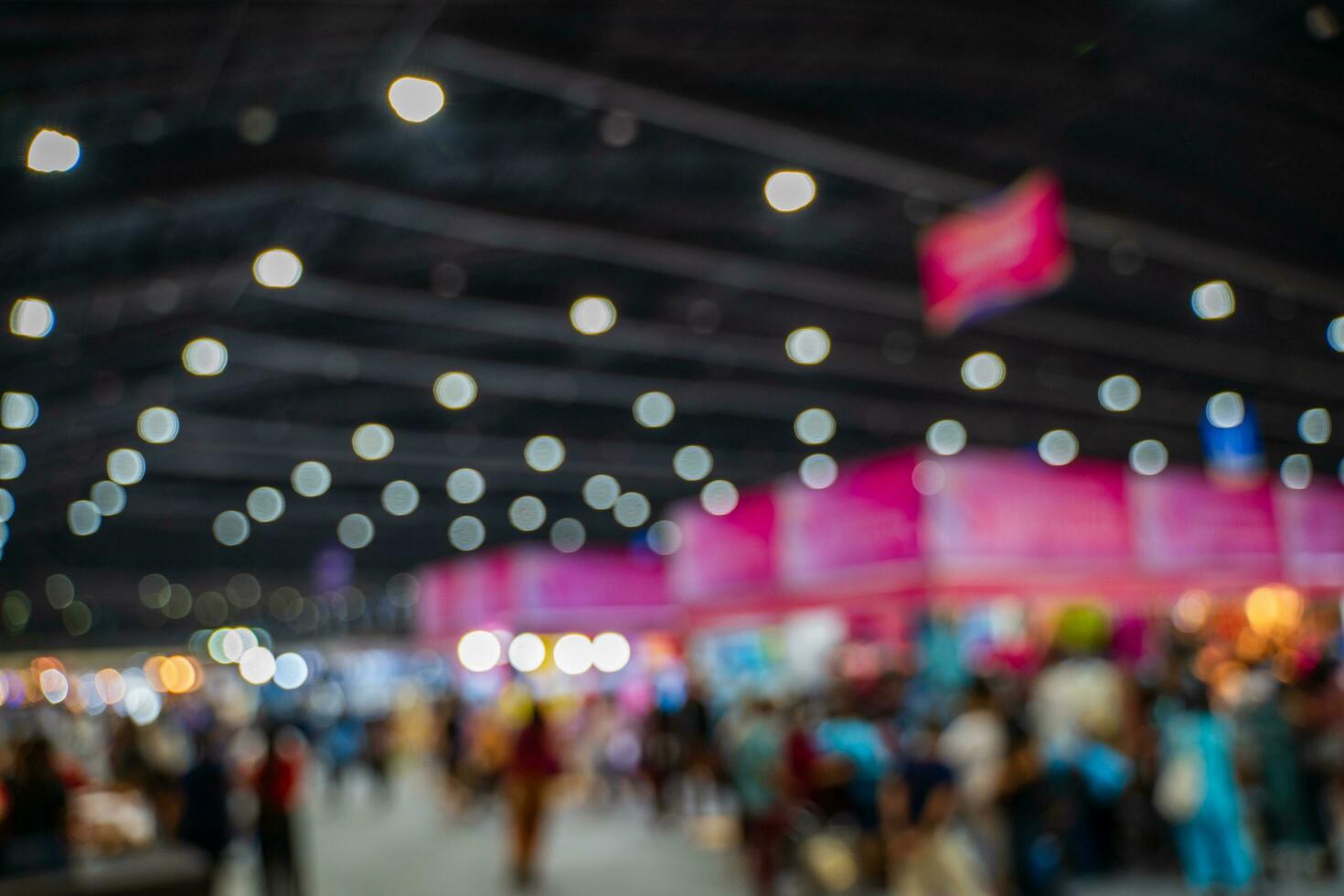 Blurred images of trade fairs in the big hall. image of people walking on a trade fair exhibition or expo where business people show innovation activity and present products in a big hall. photo