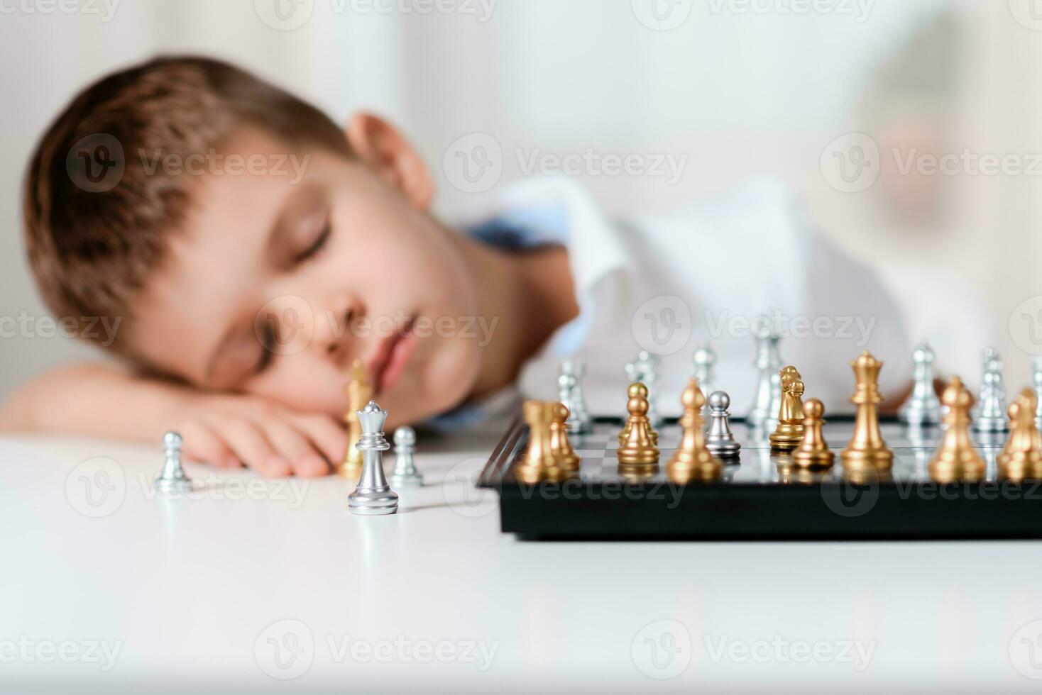 el niño jugado ajedrez y cayó dormido a el mesa foto