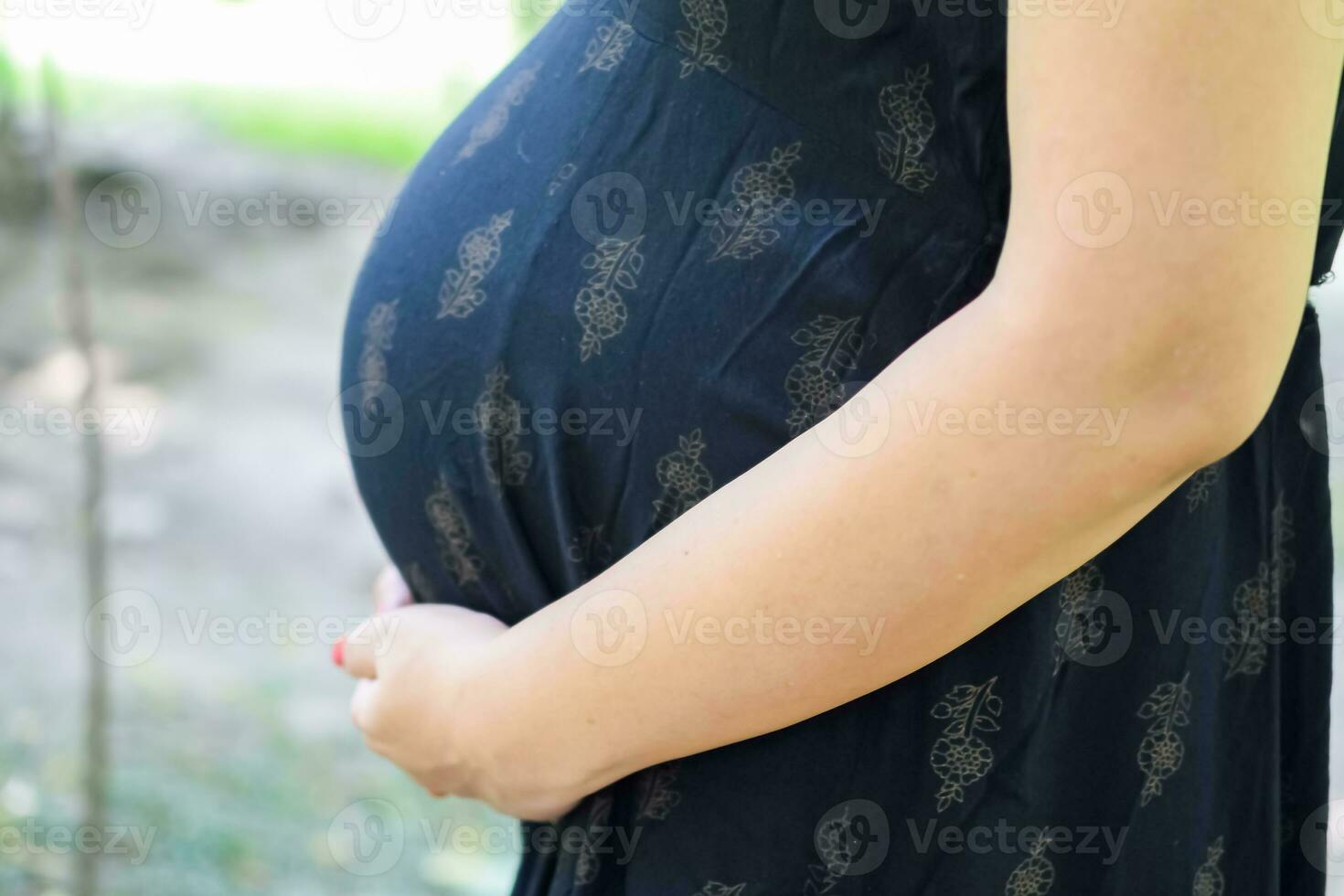 A pregnant Indian lady poses for outdoor pregnancy shoot and hands