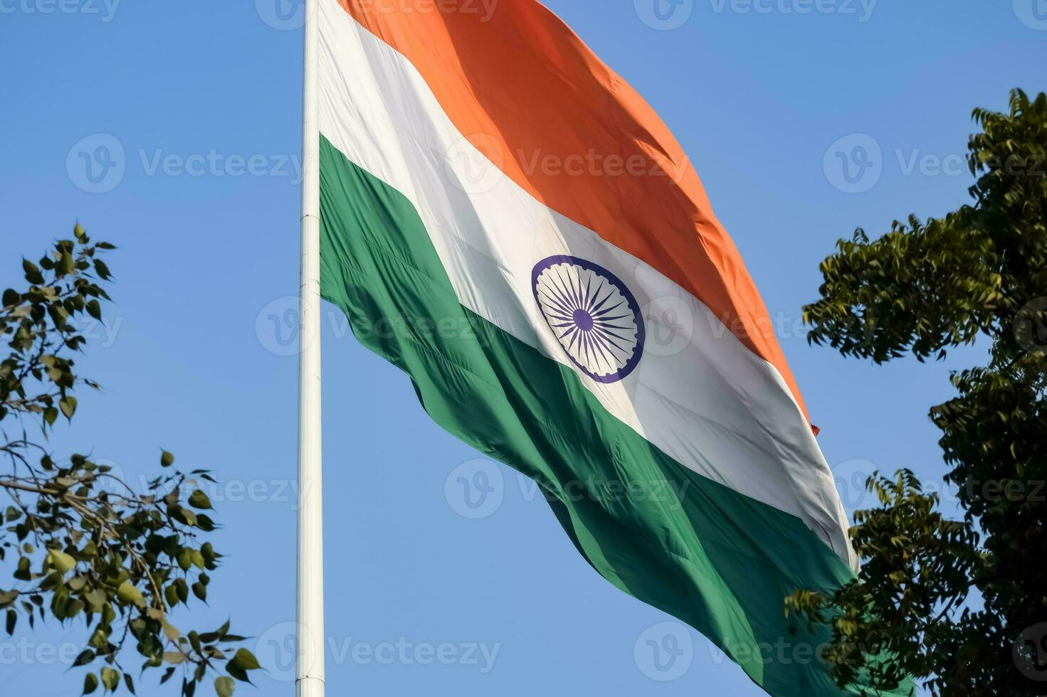 India flag flying high at Connaught Place with pride in blue sky, India flag fluttering, Indian Flag on Independence Day and Republic Day of India, tilt up shot, Waving Indian flag, Har Ghar Tiranga photo