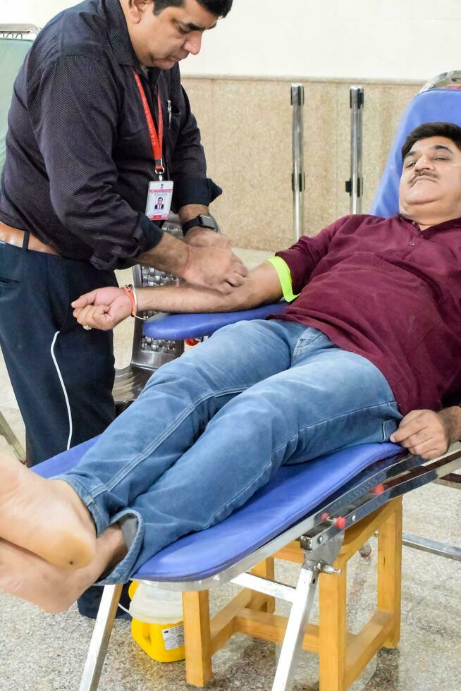 Delhi, India, June 19 2023 - Blood donor at Blood donation camp held at Balaji Temple, Vivek Vihar, Delhi, India, Image for World blood donor day on June 14 every year, Blood Donation Camp at Temple photo