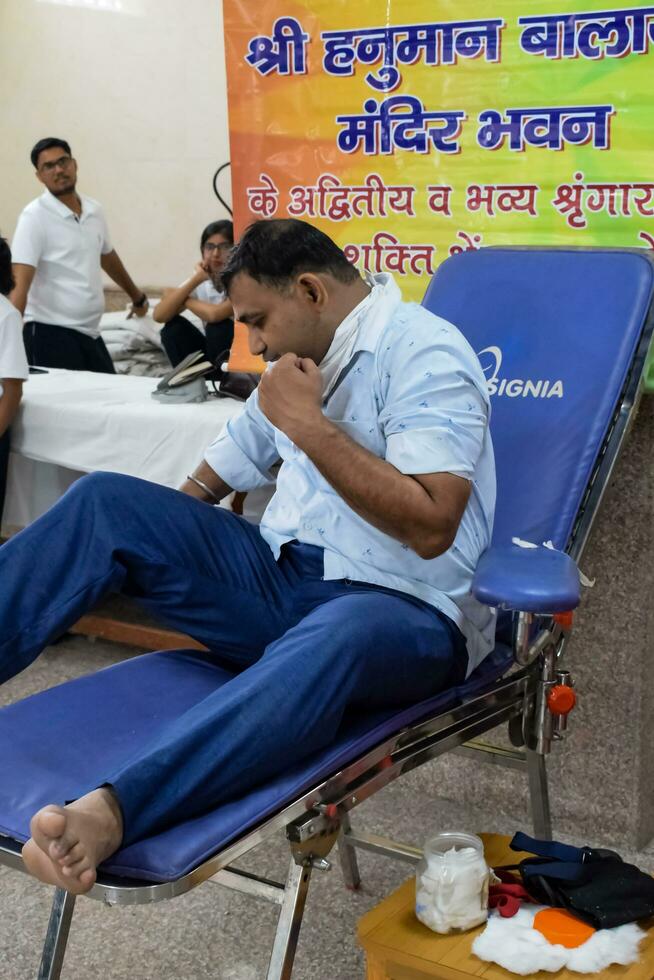 Delhi, India, July 19 2023 - Blood donor at Blood donation camp held at Balaji Temple, Vivek Vihar, Delhi, India, Image for World blood donor day on June 14 every year, Blood Donation Camp at Temple photo