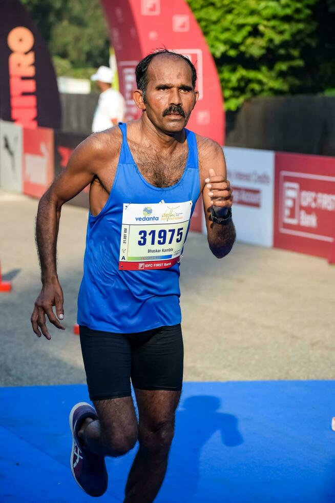 New Delhi, India - July 16 2023 - Vedanta Delhi Half Marathon race after covid in which marathon participants about to cross the finish line, Delhi Half Marathon 2022 photo