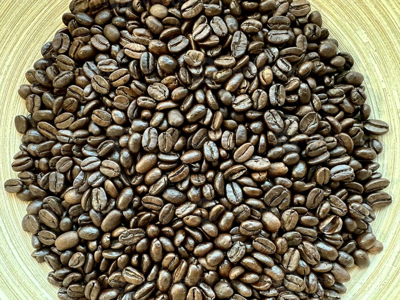 Close up top view background of aromatic brown coffee beans scattered on surface. Coffee beans texture pattern. photo