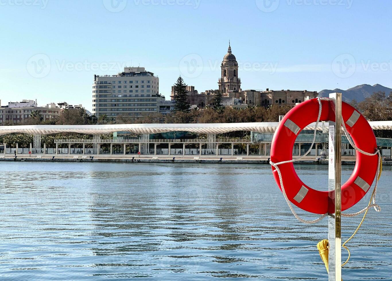 Sunny day in the Harbor of Malaga with view of the old town, Costa del Sol, Southern Andalusia, Spain. Lifebuoy sea view Malaga Puerto. photo