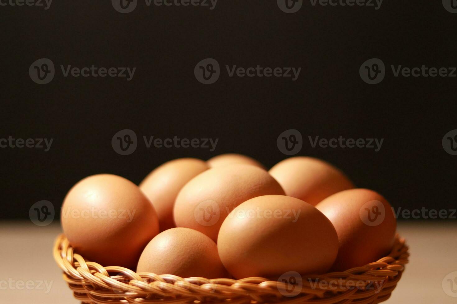 The eggs in the brown wicker basket on the table. photo