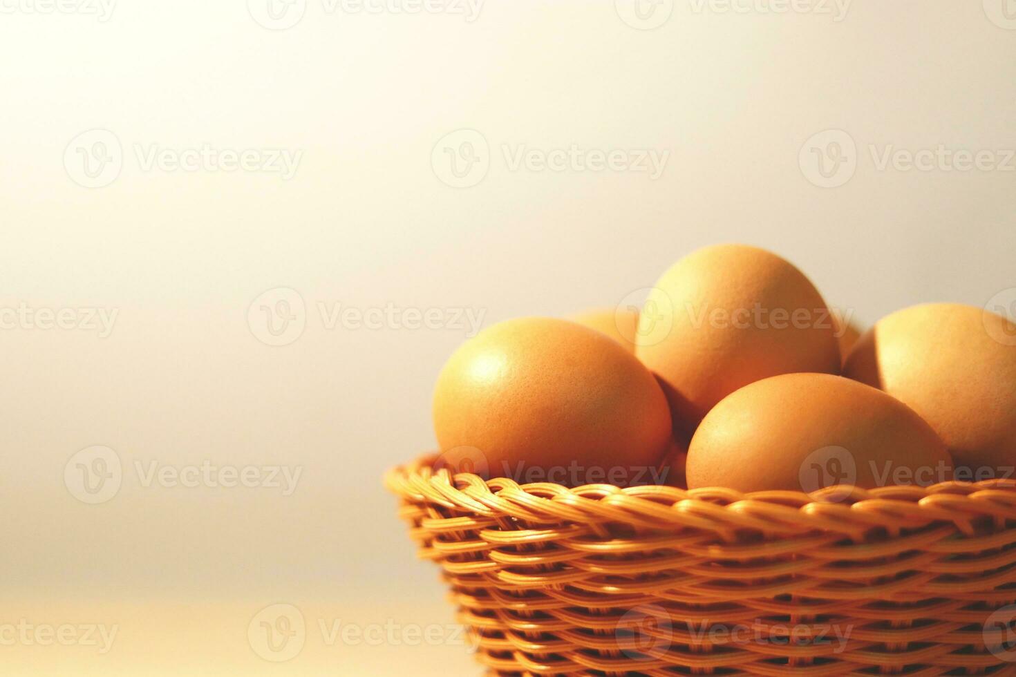 The eggs in the brown wicker basket on the table. photo