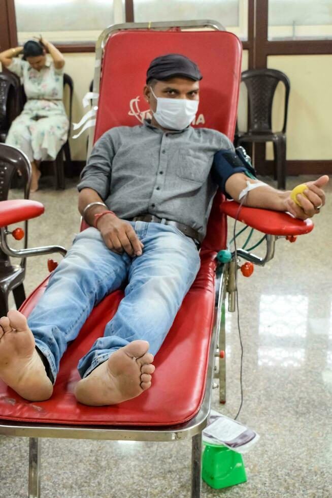 Delhi, India, June 19 2023 - Blood donor at Blood donation camp held at Balaji Temple, Vivek Vihar, Delhi, India, Image for World blood donor day on June 14 every year, Blood Donation Camp at Temple photo
