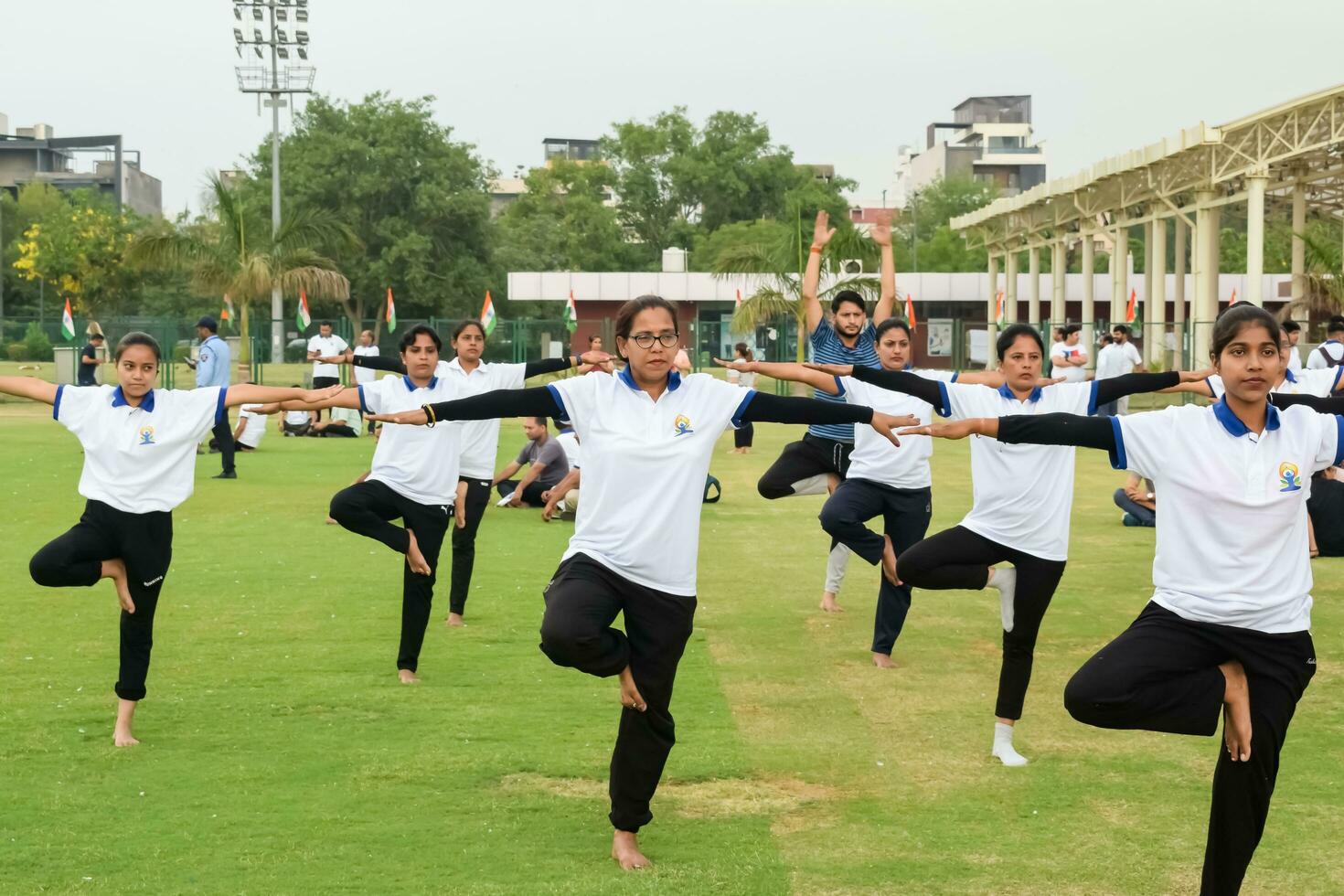 nuevo Delhi, India, junio 21, 2023 - grupo yoga ejercicio sesión para personas a yamuna Deportes complejo en Delhi en internacional yoga día, grande grupo de adultos asistiendo yoga clase en Grillo estadio foto