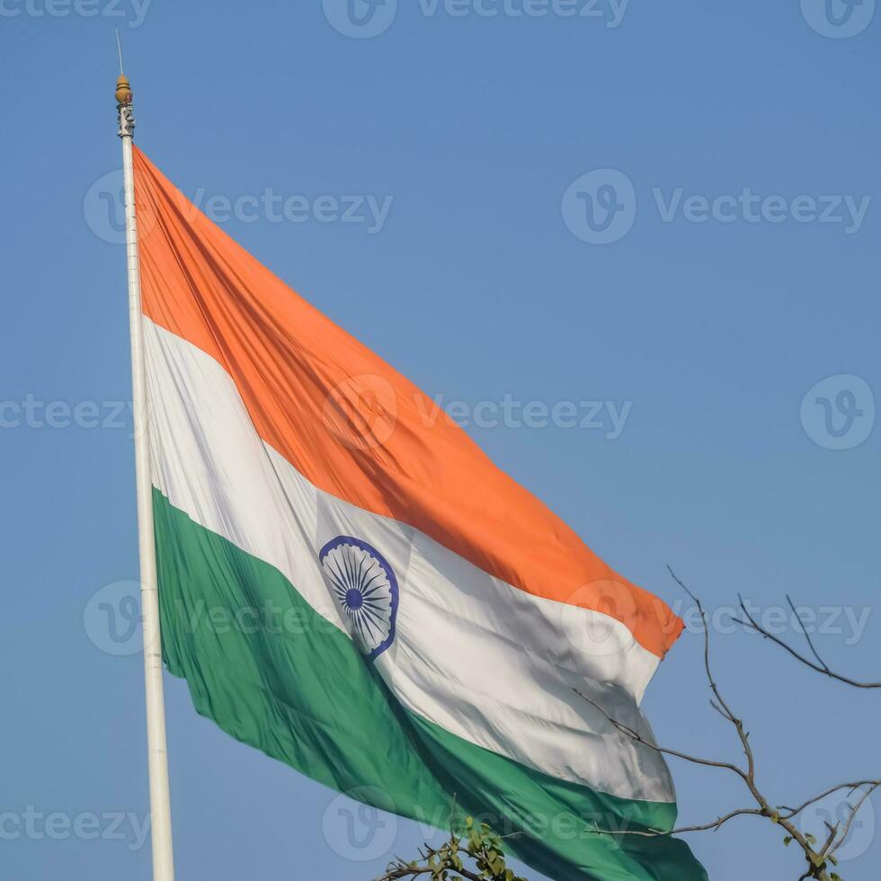 India flag flying high at Connaught Place with pride in blue sky, India flag fluttering, Indian Flag on Independence Day and Republic Day of India, tilt up shot, Waving Indian flag, Har Ghar Tiranga photo