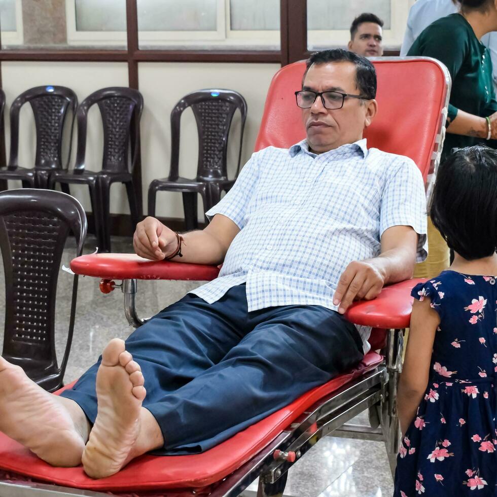 Delhi, India, July 19 2023 - Blood donor at Blood donation camp held at Balaji Temple, Vivek Vihar, Delhi, India, Image for World blood donor day on June 14 every year, Blood Donation Camp at Temple photo