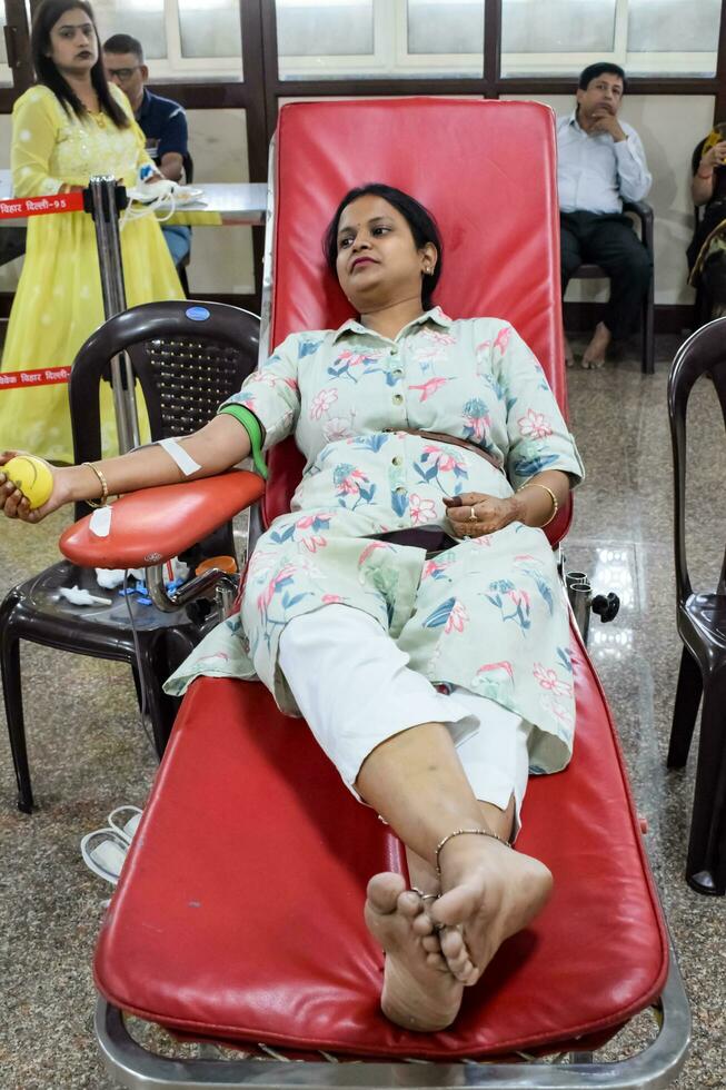 Delhi, India, June 19 2023 - Blood donor at Blood donation camp held at Balaji Temple, Vivek Vihar, Delhi, India, Image for World blood donor day on June 14 every year, Blood Donation Camp at Temple photo