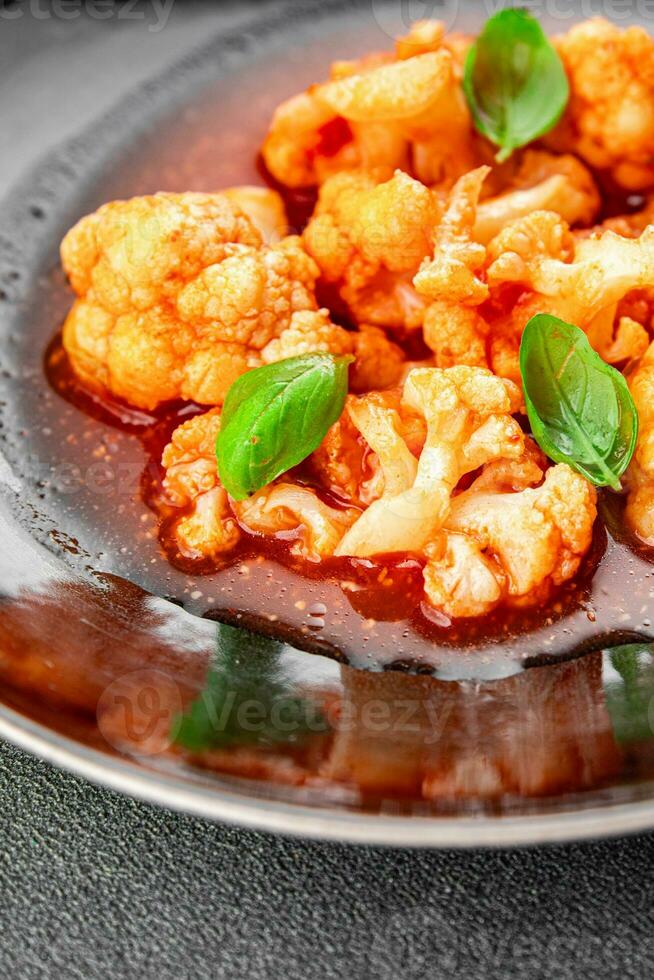 cauliflower in tomato sauce stewed vegetable second course healthy eating appetizer meal food snack on the table copy space food background rustic top view keto or paleo diet vegetarian vegan photo