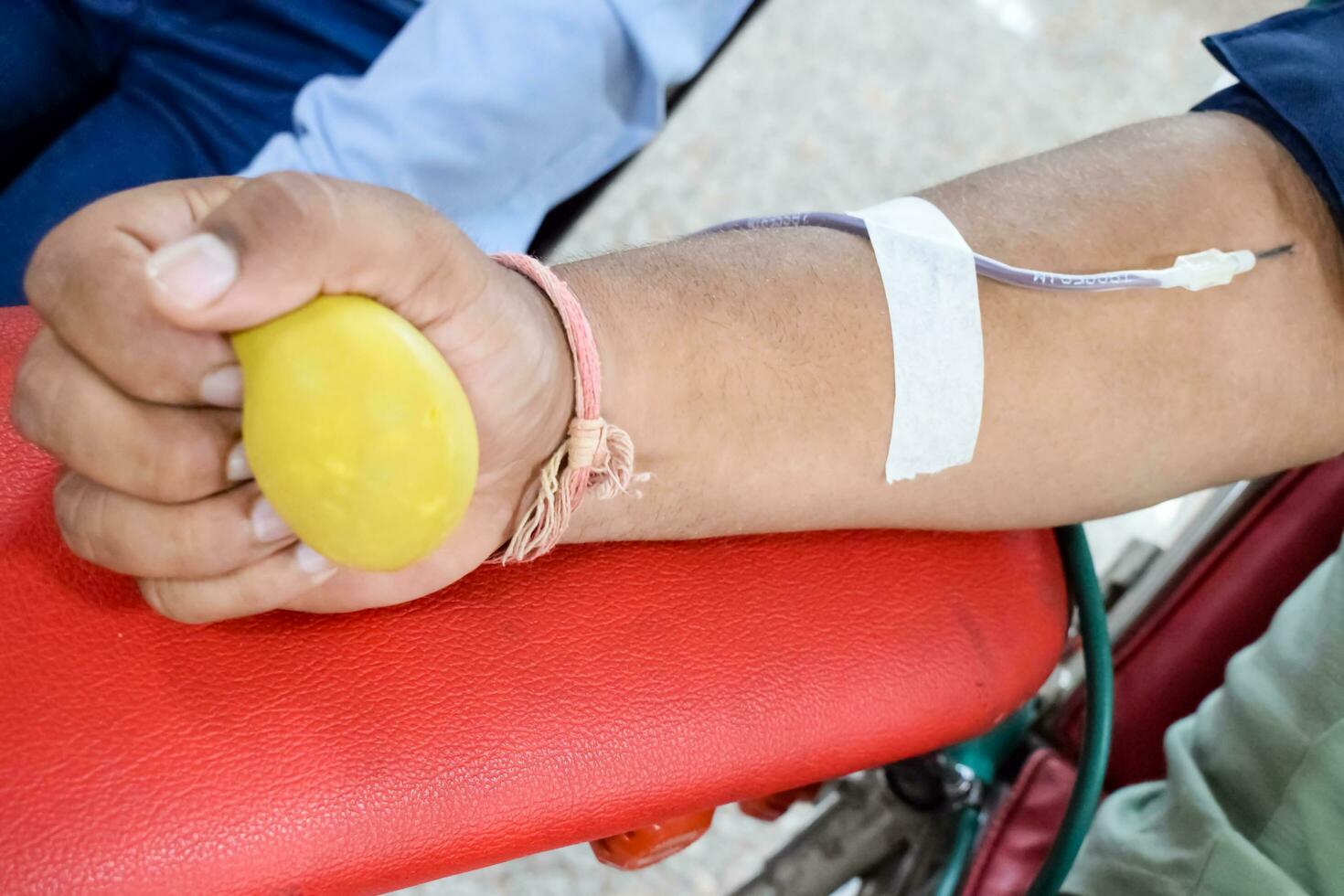 Blood donor at Blood donation camp held with a bouncy ball holding in hand at Balaji Temple, Vivek Vihar, Delhi, India, Image for World blood donor day on June 14 every year, Blood Donation Camp photo