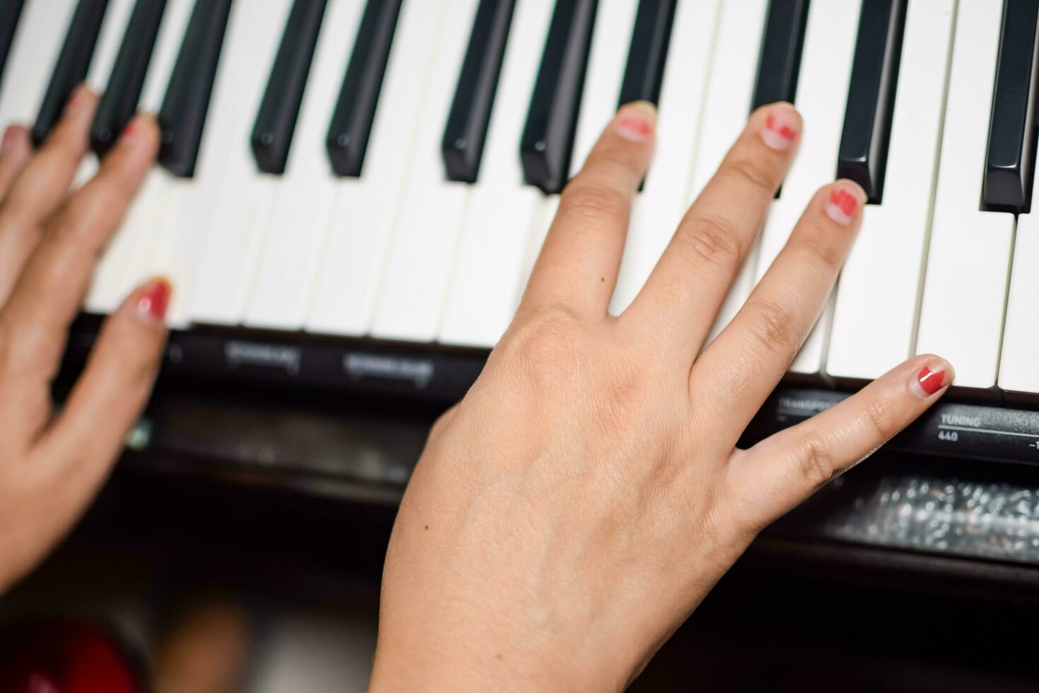 Asian boy playing the synthesizer or piano. Cute little kid learning how to play piano. Child's hands on the keyboard indoor. photo