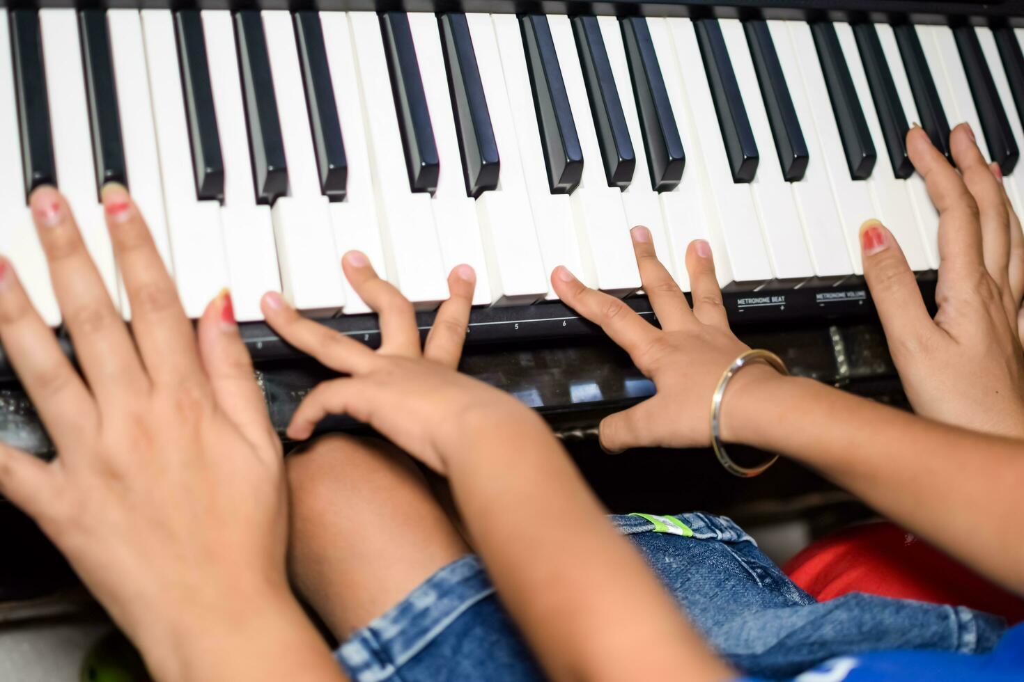 Asian boy playing the synthesizer or piano. Cute little kid learning how to play piano. Child's hands on the keyboard indoor. photo