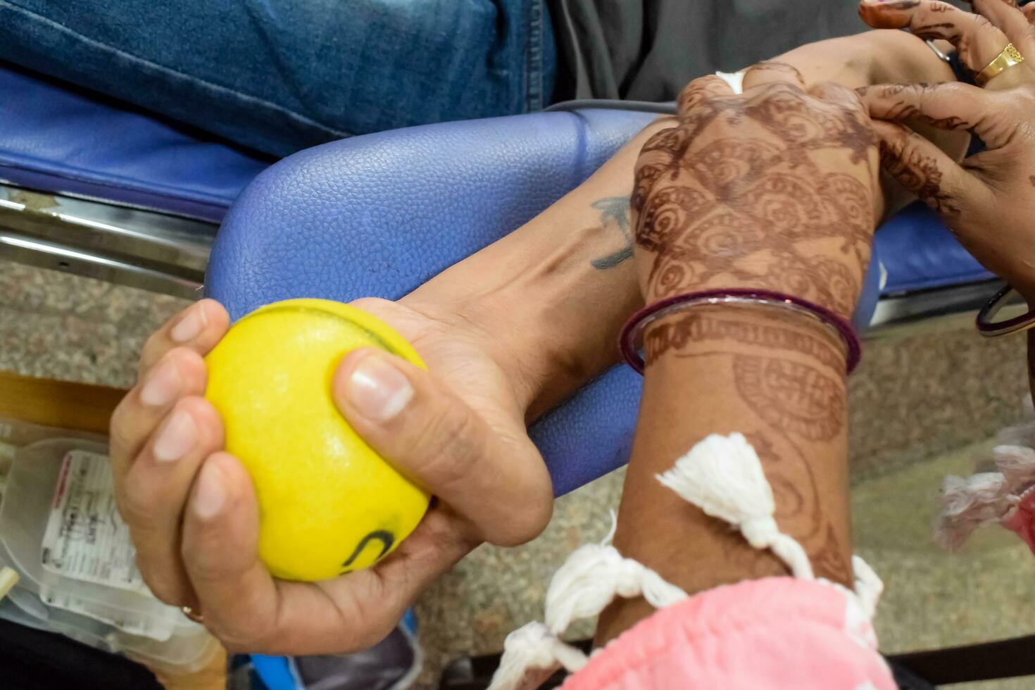 Blood donor at Blood donation camp held with a bouncy ball holding in hand at Balaji Temple, Vivek Vihar, Delhi, India, Image for World blood donor day on June 14 every year, Blood Donation Camp photo