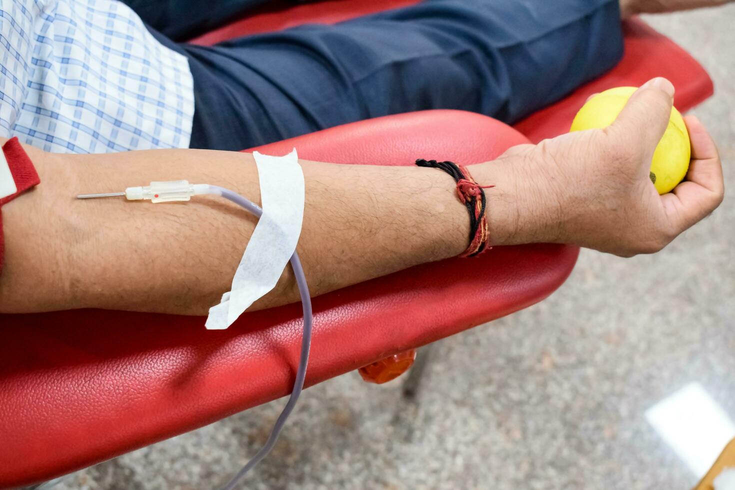 donante de sangre en el campamento de donación de sangre sostenido con una pelota hinchable en la mano en el templo balaji, vivek vihar, delhi, india, imagen para el día mundial del donante de sangre el 14 de junio de cada año, campamento de donación de sangre foto