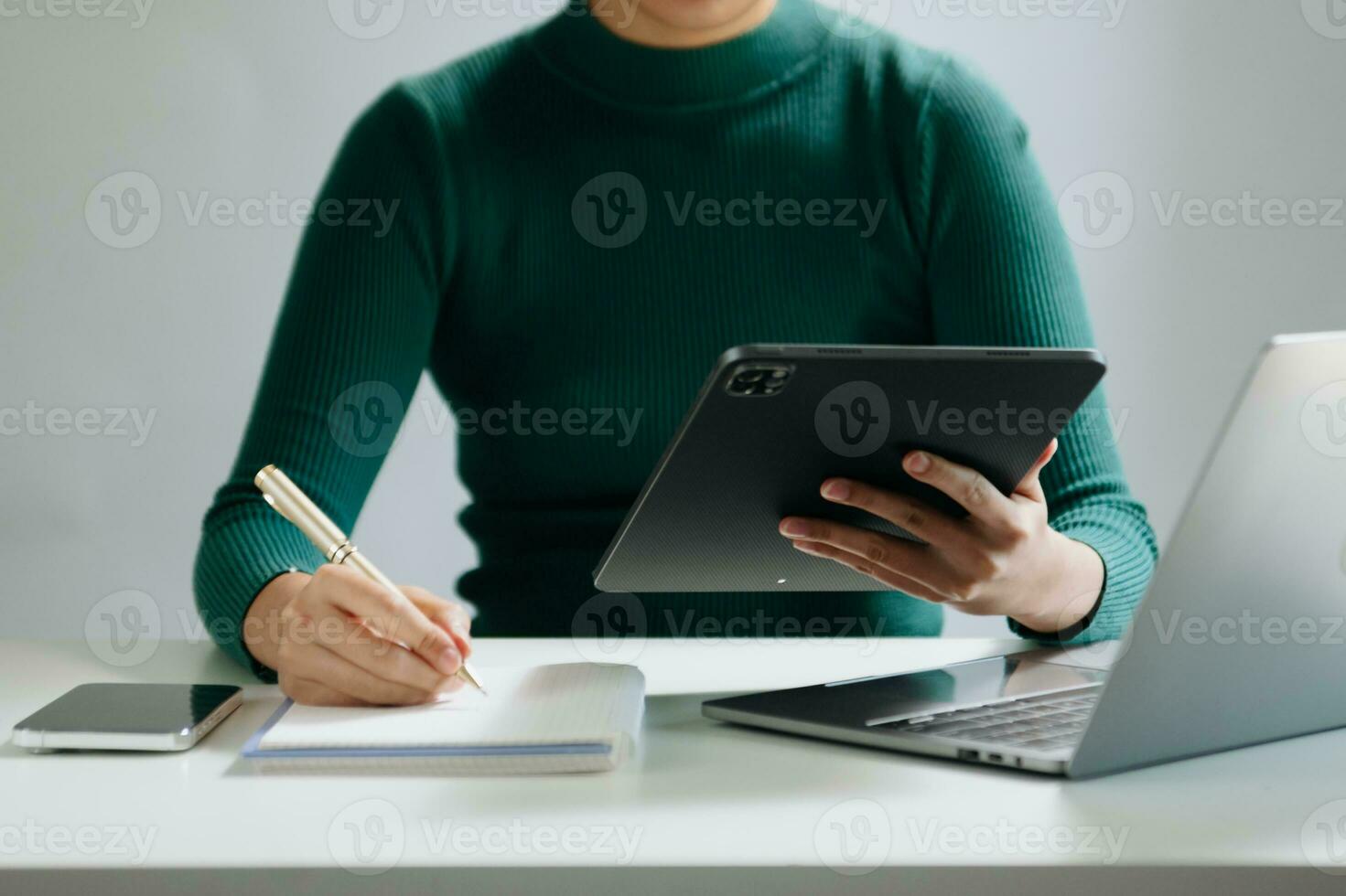 Close-up view of young professional businessman writing his idea concepts on notebook while working on his project photo