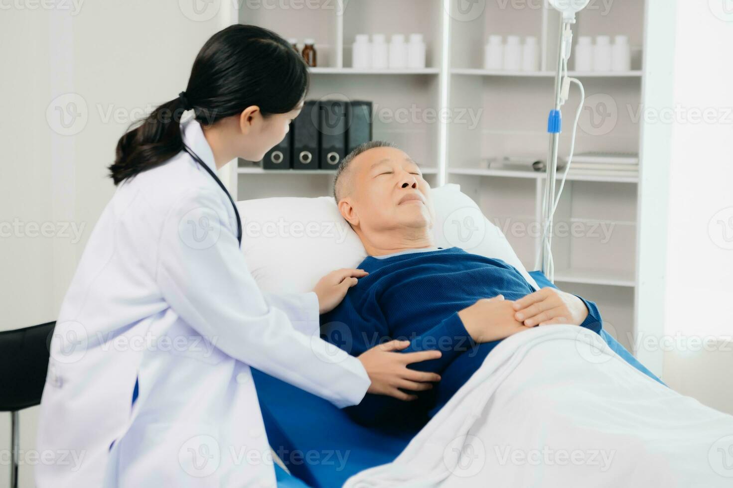 Doctor discussing treatment with Senior male patient talking and laughing sitting on examination bed in clinic or hospital photo