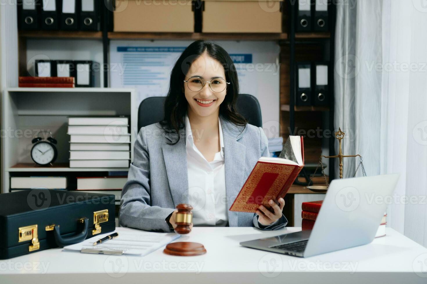 justicia y ley concepto. asiático hembra juez en un sala de justicia en de madera mesa y consejero o masculino abogado trabajando en moderno oficina. foto