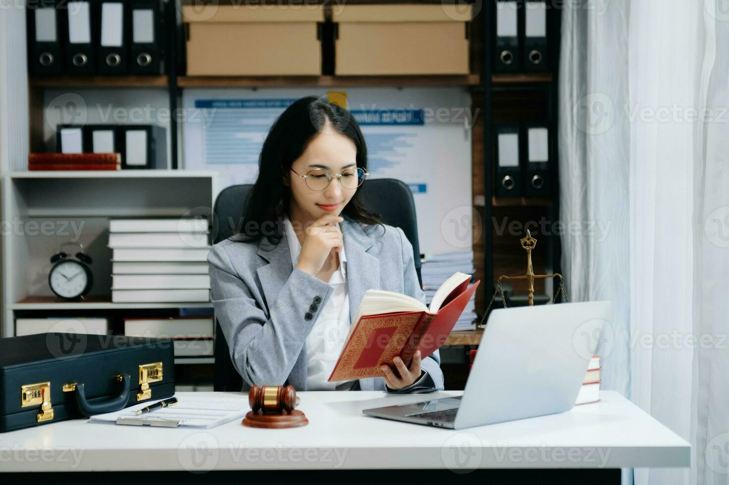 Woman lawyer reading legal book with gavel on table in office. justice and law ,attorney concept. photo