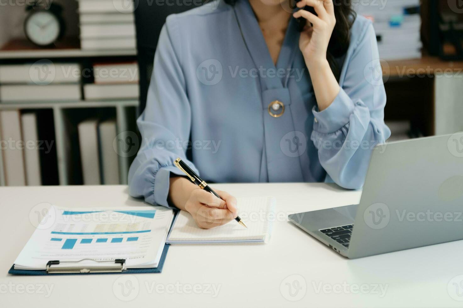 businesswoman hand writing on the notepad with new modern computer strategy diagram as concept photo