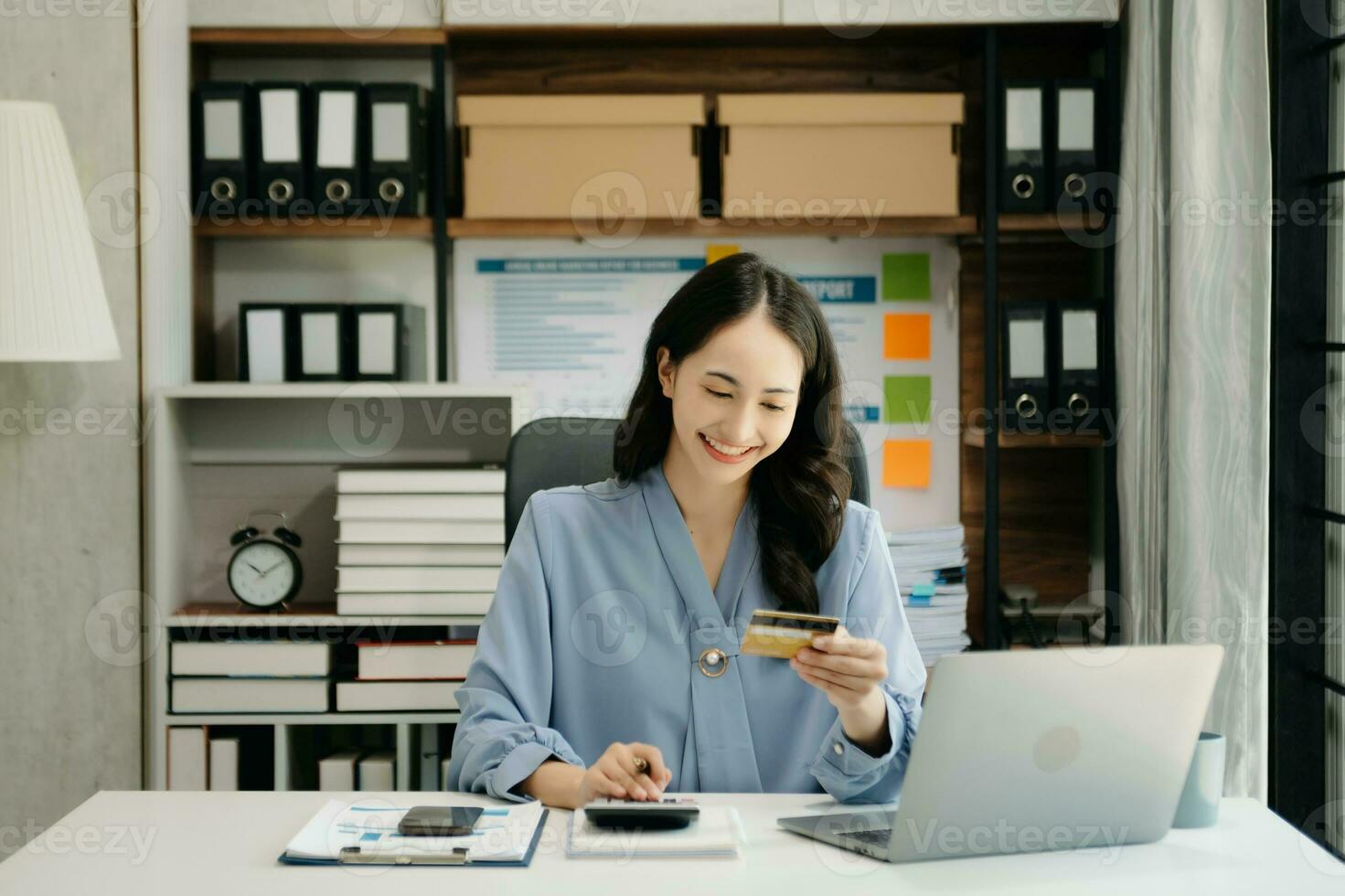 Woman using smart phone for mobile payments online shopping, omni channel, sitting on table, virtual icons graphics interface screen photo