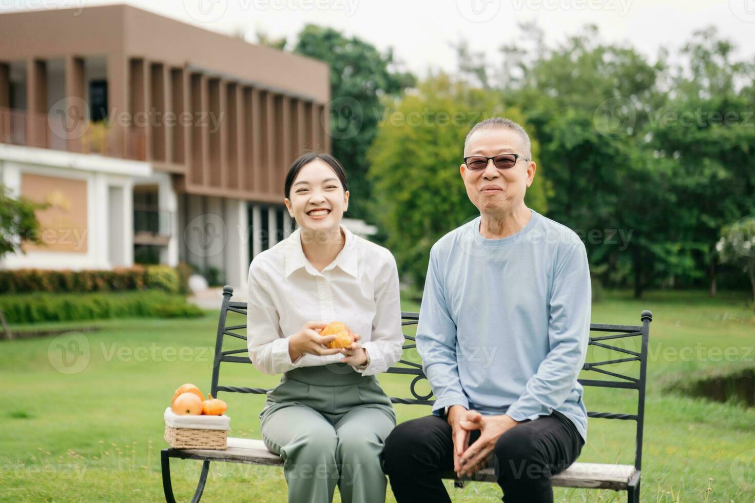 Happy adult granddaughter and senior grandfather having fun enjoying talk while relaxing sitting outdoor in park photo