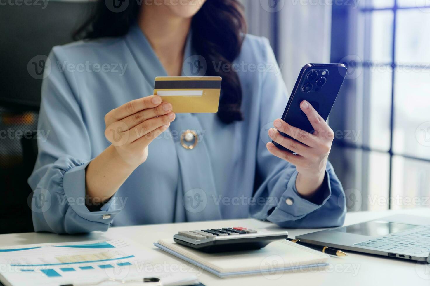 Woman using smart phone for mobile payments online shopping, omni channel, sitting on table, virtual icons graphics interface screen photo